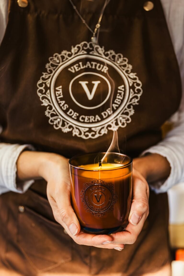 Inicio Manos sosteniendo una vela de cera de abeja encendida en vaso de cristal ámbar